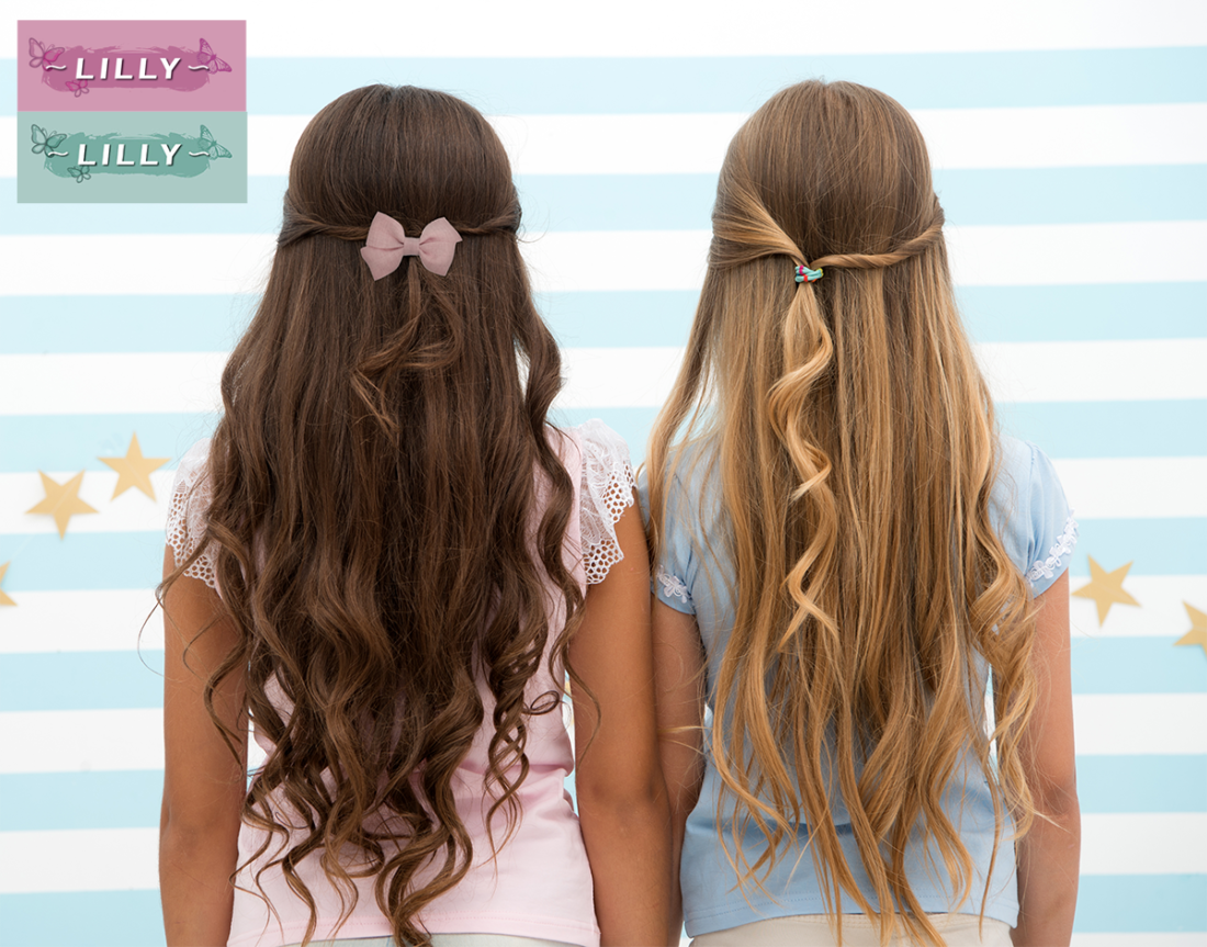 Zwei Mädchen mit langen gewellten Haaren tragen Haarschmuck von Lilly von Trisa Accessoires, vor blau-weiss gestreiftem Hintergrund